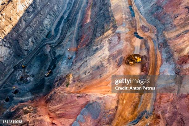 aerial view of open pit iron ore and heavy mining equipment. - natural phenomena stock pictures, royalty-free photos & images
