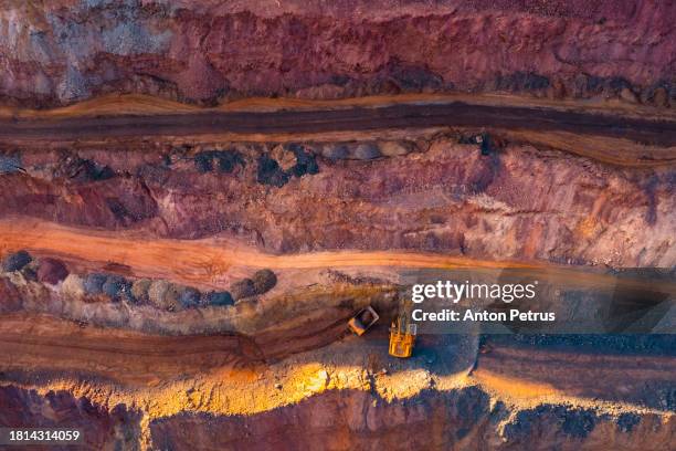 aerial view of open pit iron ore and heavy mining equipment. - open pit mine stock pictures, royalty-free photos & images