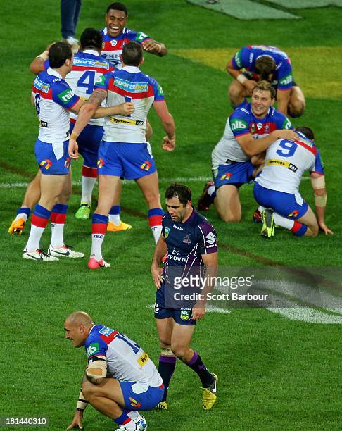 Knights players celebrate at full time as Cameron Smith of the Storm looks dejected during the NRL Second Semi Final match between the Melbourne...