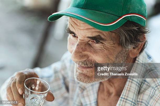 portrait of a senior man drinking ouzo - ouzo stock pictures, royalty-free photos & images