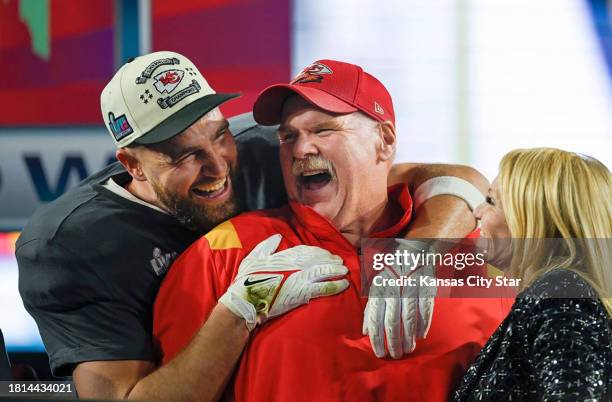 Kansas City Chiefs tight end Travis Kelce, left, hugs head coach Andy Reid as Tammy Reid looks on after the Chiefs won Super Bowl LVII against the...
