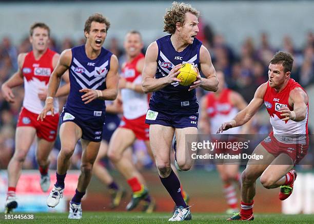 David Mundy of the Dockers runs with the ball away from Ben McGlynn of the Swans during the AFL Second Preliminary Final match between the Fremantle...