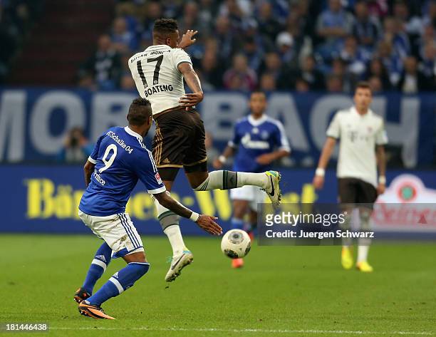 Kevin-Prince Boateng of Schalke tackles Jerome Boateng of Munich during the Bundesliga match between FC Schalke 04 and FC Bayern Muenchen at...