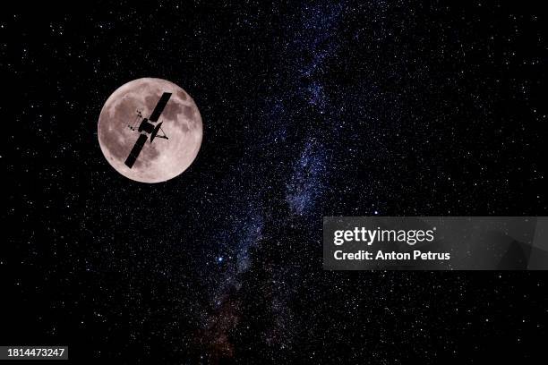 communications satellite on the background of the moon. satellite connection - satellietfoto stockfoto's en -beelden