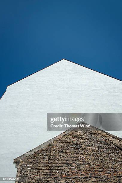 new building on top of an old building - dachgiebel stock-fotos und bilder