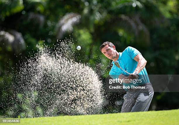 golfer playing out of a bunker - golf bunker stock-fotos und bilder