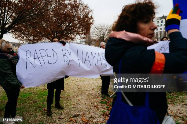 Demonstrators hold a banner reading "Raped by Hamas" during a rally organised by the Rape is Rape committee to "denounce the silence of international...