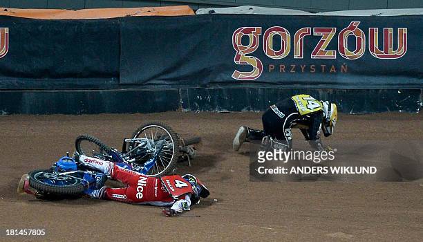 Poland's Tomasz Gollob lies on the track while Great Britain's Tai Woffinden tries to get up after a collision between the two drivers during the...
