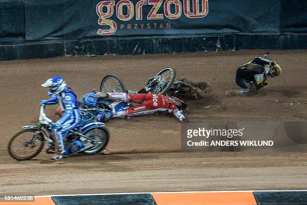 Slovenia's Matej Zagar passes by Poland's Tomasz Gollob who lies on the track while Great Britain's Tai Woffinden tries to get up after a collision...