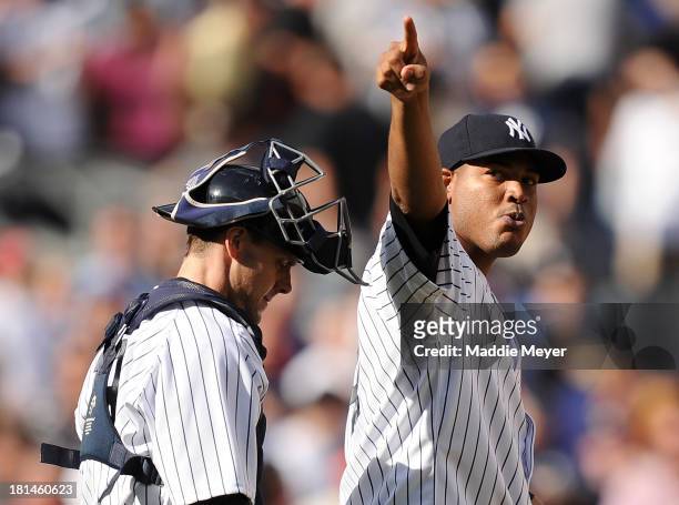 Ivan Nova of the New York Yankees celebrates a win over the San Francisco Giants with Chris Stewart during interleague play on September 21, 2013 at...