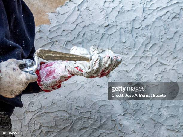 hands of a bricklayer with cement working on a wall. - applying plaster stock pictures, royalty-free photos & images
