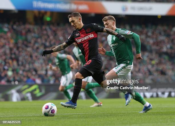 Alejandro Grimaldo of Bayer 04 Leverkusen is challenged by Mitchell Weiser of Werder Bremen during the Bundesliga match between SV Werder Bremen and...