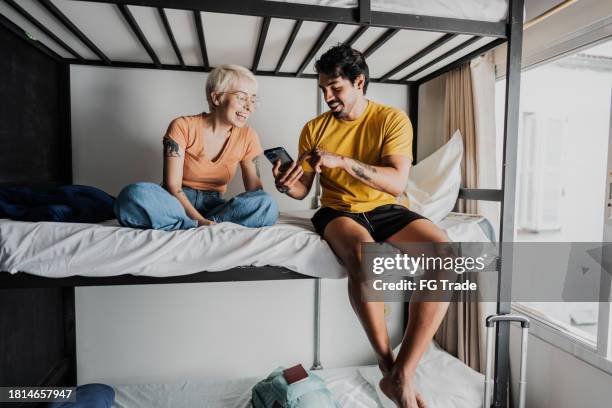 roommates talking in bedroom at hostel - roommates guys stock pictures, royalty-free photos & images