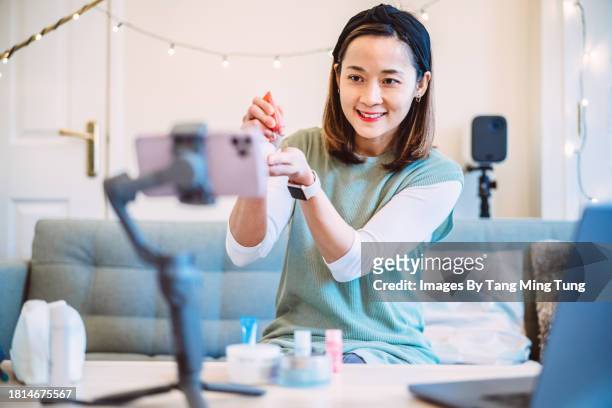 young beautiful asian female influencer doing a vlog post about organic skincare products at home - beauty youtube stock pictures, royalty-free photos & images