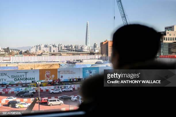Man looks at a view towards the Lotte Tower in the Gangnam district during a job fair for North Korean defectors, in Seoul on December 1, 2023. Over...