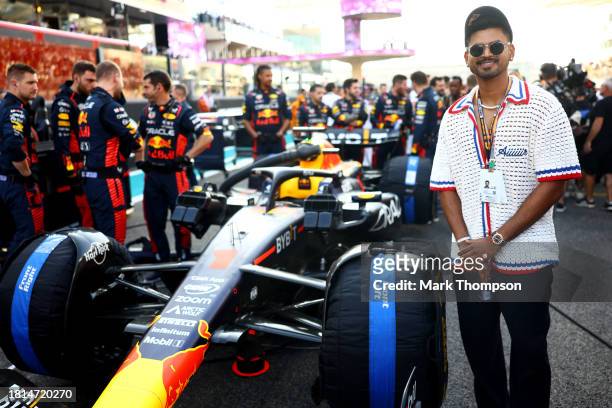 Shreyas Iyer poses for a photo with the car of Max Verstappen of the Netherlands and Oracle Red Bull Racing on the grid prior to the F1 Grand Prix of...