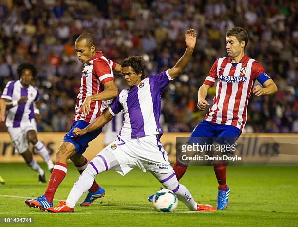 Joao Miranda of Club Atletico de Madrid blocks Humberto Osorio of Real Valladolid CF while Gabi looks on during the La Liga match between Real...