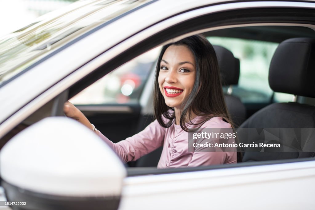 Driver woman in suv car smiling looking at camera