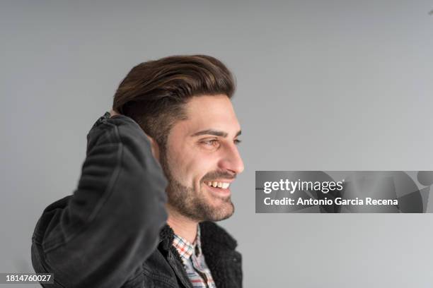 smiling man shot on grey background while smile and touch his head - plaid shirt isolated stock pictures, royalty-free photos & images