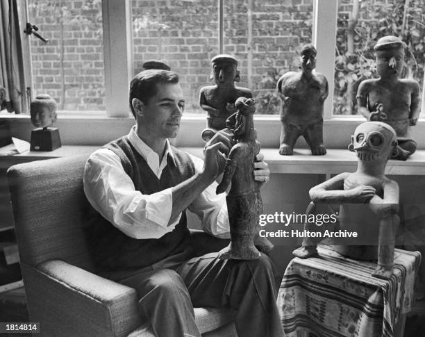 American actor John Gavin holds a 1,500 year-old figure from his private collection, May 6, 1962.