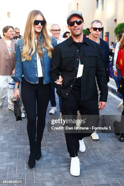 Jason Statham and Rosie Huntington-Whiteley walk in the Paddock prior to the F1 Grand Prix of Abu Dhabi at Yas Marina Circuit on November 26, 2023 in...