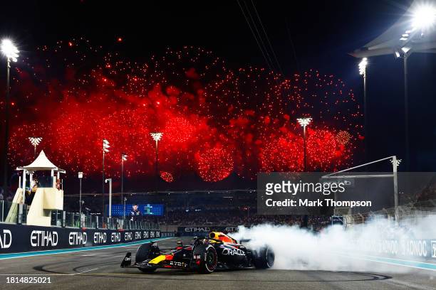 Race winner Max Verstappen of the Netherlands driving the Oracle Red Bull Racing RB19 performs donuts on track during the F1 Grand Prix of Abu Dhabi...