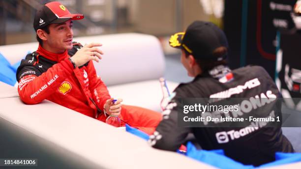 Second placed Charles Leclerc of Monaco and Ferrari talks to Third placed George Russell of Great Britain and Mercedes in the cool down room during...