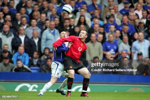 August 13: Wayne Rooney of Manchester Utd & Tony Hibbert of Everton challenge during the Premier League match between Everton and Manchester United...