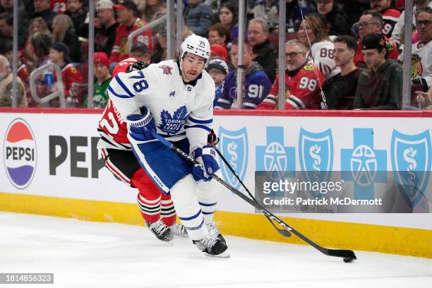 Brodie of the Toronto Maple Leafs skates with the puck against Reese Johnson of the Chicago Blackhawks during the second period at the United Center...