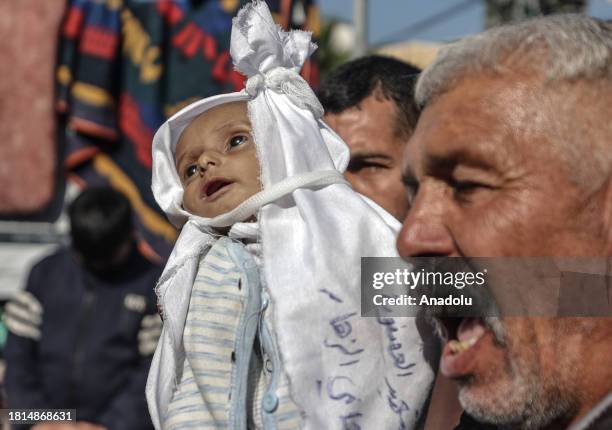 Dead body of a 5-month-old Palestinian baby named Muhammad Hani Al-Zahar, is brought to the Al-Aqsa Martyrs Hospital by his mother Asmahan Attia...