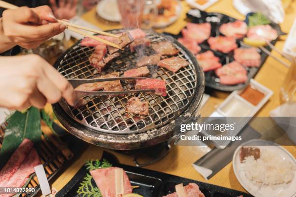 crop shot asia sonrisa mujeres con wagyu a5 steak stick con salsa bbq y pimienta osaka japan streetfood - carne de vaca wagyu fotografías e imágenes de stock