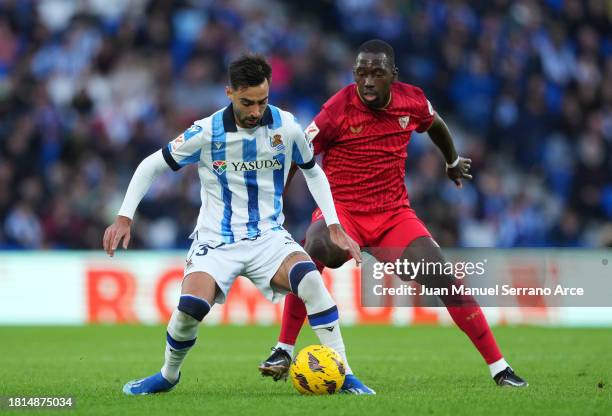 Brais Mendez of Real Sociedad controls the ball under pressure from Boubakary Soumare of Sevilla FC during the LaLiga EA Sports match between Real...