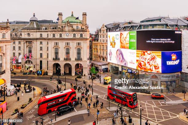 illuminated piccadilly circus with red double-decker buses and advertising screens, london, england, uk - piccadilly circus bildbanksfoton och bilder