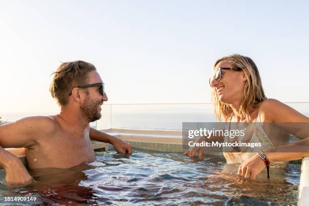 couple relaxing in a private hot tub outdoors - outdoor hot tub stock pictures, royalty-free photos & images