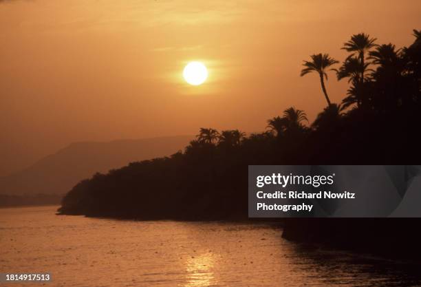 Setting sun above the bank of the Nile River at near Aswan, Egypt. Sept. 09, 1995.