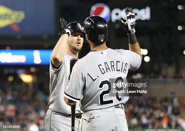 Jeff Keppinger of the Chicago White Sox celebrates with teammate Leury Garcia after scoring on the double by Bryan Anderson in the ninth inning of...