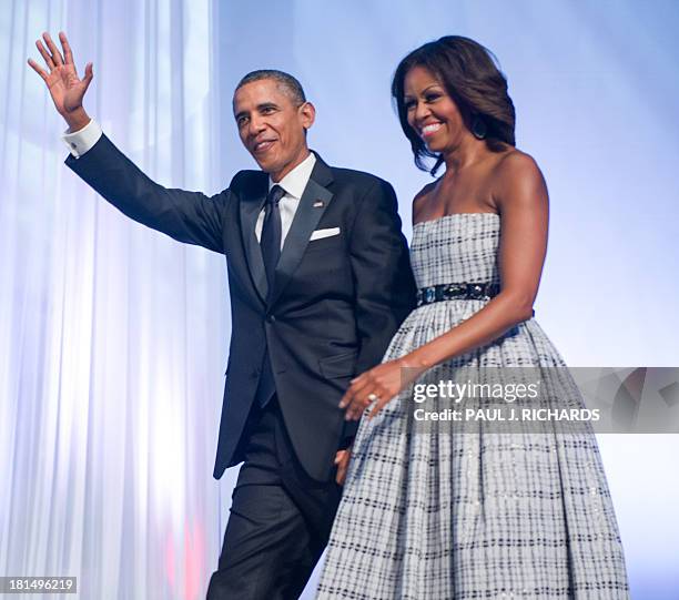 President Barack Obama and First Lady Michelle Obama wave as they attend the The Congressional Black Caucus Foundation, Inc. Annual Phoenix Awards...
