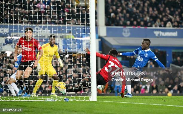Kobbie Mainoo of Manchester United clears the shot of Dwight McNeil of Everton off the line during the Premier League match between Everton FC and...