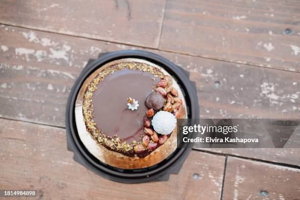 small chocolate bento cake with 1 golden candle on wooden parquet floor, top view - 1 year anniversary stock pictures, royalty-free photos & images