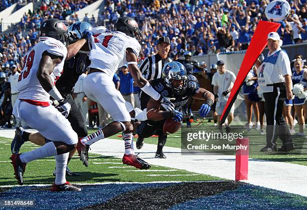 Brandon Hayes of the Memphis Tigers dives over the goal line for a touchdown run against Sterling Young of the Arkansas State Red Wolves on September...
