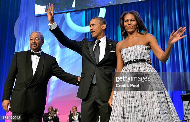 President Barack Obama and first lady Michelle Obama wave as they greet Rep. Chaka Fattah as they arrive on stage for the Congressional Black Caucus...