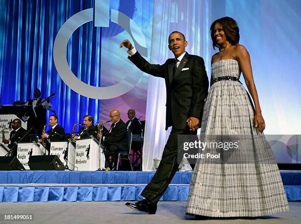 President Barack Obama and first lady Michelle Obama arrive on stage for the Congressional Black Caucus Foundation Annual Phoenix Awards dinner,...