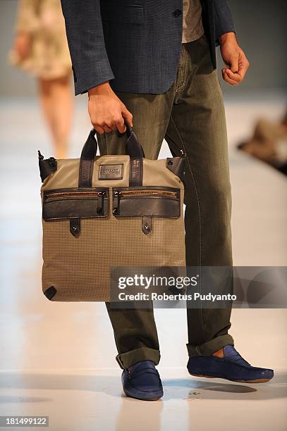 Model shows details of handbag collection as he walks the runway at Versace Collection show during Ciputra World Fashion Week 2013 on September 21,...