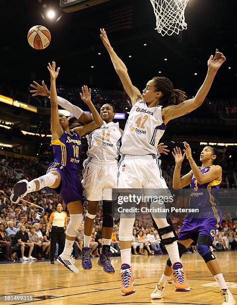 Lindsey Harding of the Los Angeles Sparks is fouled as she attempts a shot against Alexis Hornbuckle and Brittney Griner of the Phoenix Mercury...