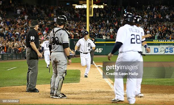 Andy Dirks of the Detroit Tigers rounds third base after hitting a three run home run in the ninth inning scoring Prince Fielder and Victor Martinez...