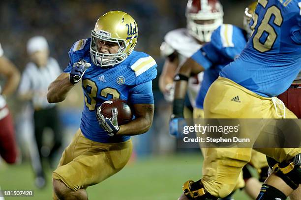 Running back Steven Manfro of the UCLA Bruins carries the ball on a 20 yard touchdown pass play in the second quarter against the New Mexico State...