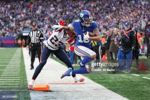 Kyle Dugger of the New England Patriots pushed Isaiah Hodgins of the New York Giants while Hodgins scores a touchdown during the second quarter at...