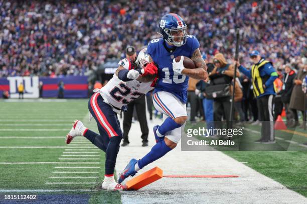 Kyle Dugger of the New England Patriots pushes Isaiah Hodgins of the New York Giants while Hodgins scores a touchdown during the second quarter at...