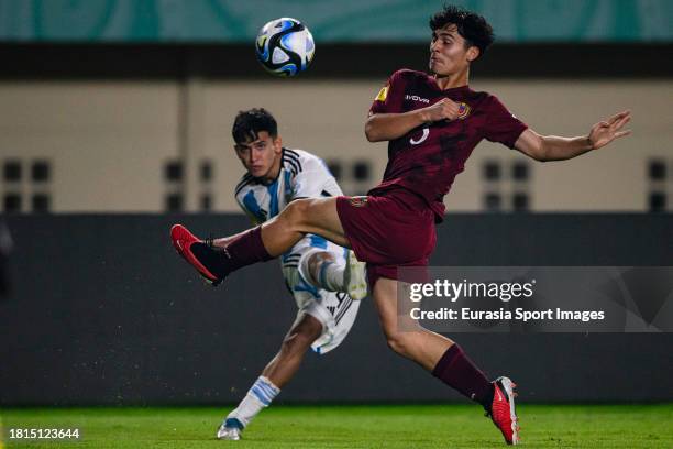 Dylan Gorosito of Argentina looks to bring the ball down while is blocked by Santiago Silva of Venezuela during FIFA U-17 World Cup Round of 16 match...
