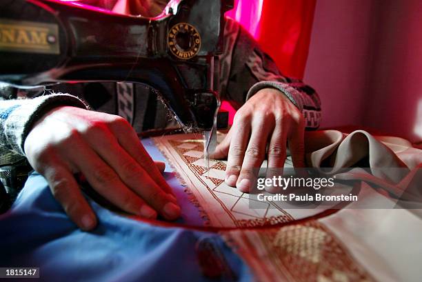Afghan man makes burqas at a home February 25, 2003 in Kabul, Afghanistan. A burqa, a body-length veil that is the cultural norm in Afghanistan,...